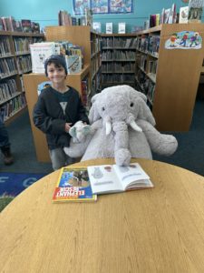 A student with Veda the stuffed elephant at the North Greenbush Library