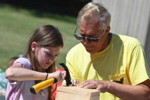 A student hammers a nail into a toolbox at Green Meadow Elementary School