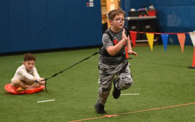 A student pulls another student in a sled during the Speed Unit of Physical Education class.